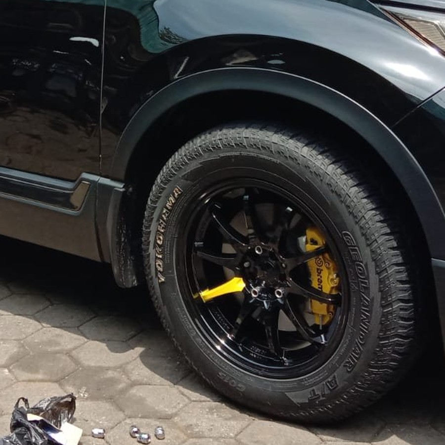 Close-up velg alloy hitam sporty pada mobil